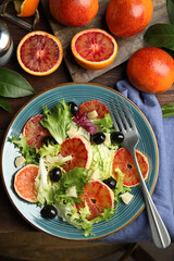 Delicious sicilian orange salad served on wooden table, flat lay