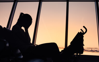 Sad single mother sitting at airport. flee, disaster, refugee of war concept  