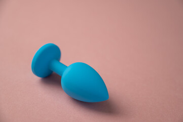 Blue anal plug on a pink background. Adult toy for alternative sex