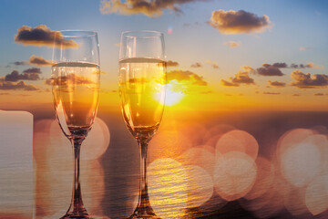 two glasses of champagne against sunset sky