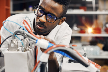 African engineer programming equipment with tablet at factory