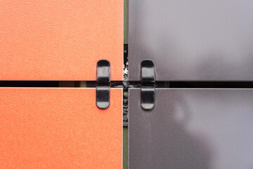 Red and black square ventilated ceramic panels installed on the facade of the building. Special...