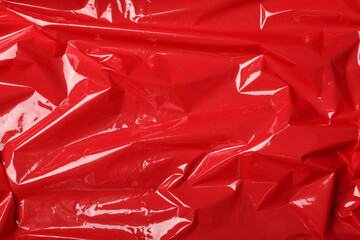 Red plastic stretch wrap as background, top view