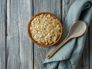 Gluten free wholegrain oat flakes in wooden bowl.