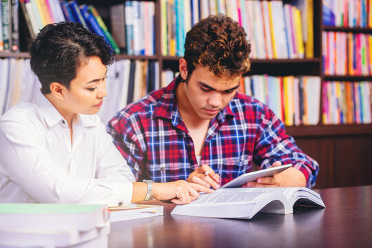 Asian College Students Sitting Reading, Studying, Examining, Tutor Books With Friends. People Learning Education Concept