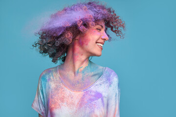 Merry woman shaking off bright pigment from curly hair
