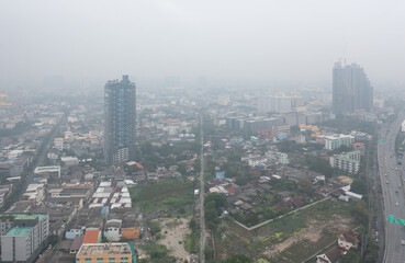 Obraz premium Aerial view of highway street road at Bangkok Downtown Skyline, Thailand. Financial district and business centers in urban city in Asia. Skyscraper buildings with fog. Air pollution pm2.5