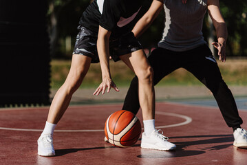 Naklejka premium Sports and recreation concept two male basketball players enjoying playing basketball together on the sports ground