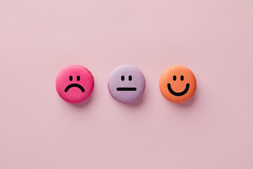Colorful macarons with happy, neutral and sad faces. Customer rating and evaluation.