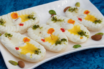 Cham Cham Mithai Also Called Rasgulla Malai Chaap, Chomchom Or Rosogolla Chamcham Is Made Of Milk, Mawa, Khoya, Pista, Kesar, Khova, Paneer, Chenna, Chhena, Dry Fruits Stuffing And Dunked In Chasni