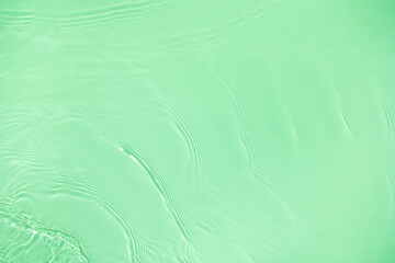 Transparent green clear water surface texture with ripples, splashes and bubbles. Abstract nature background Water waves in sunlight with copy space Cosmetic moisturizer micellar toner emulsion