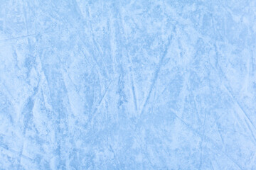 Empty ice rink with skate marks after the session outdoor. skating ice rink texture covered with snow in daylight. Close up of blue ice rink floor, copy space