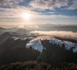 Beautiful landscape with creeping fogs on the snowy mountain slopes of the Rhodopes, Bulgaria in the winter morning