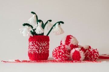 Close up red and white yarn strains of crochet vase and tassel snowdrops flowers, basket and...