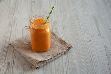 Homemade Carrot Clementine Banana Smoothie in a Glass Jar, side view. Copy space.