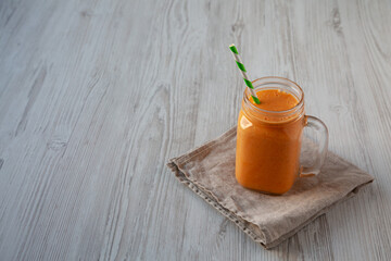 Homemade Carrot Clementine Banana Smoothie in a Glass Jar, side view. Space for text.