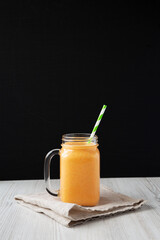Homemade Carrot Clementine Banana Smoothie in a Glass Jar; side view.