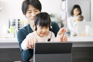 子供にテレワークの邪魔をされるアジア人男性