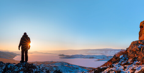 A man watching the view from the top of the hill - Beautiful winter landscape of frozen Baikal...