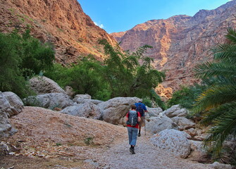 Senior couple hiking along Wadi Shab in Oman - obrazy, fototapety, plakaty