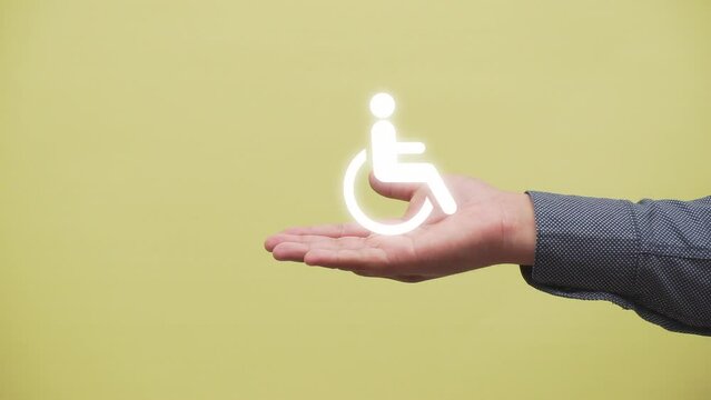 concept of disability. hand shows a symbol of person in wheelchair .inclusion. equality