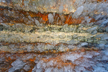 Ice and snow patterns and icicles on rocks in the cave - The rock on the frozen lake Baikal is covered with a thick layer - Baikal lake