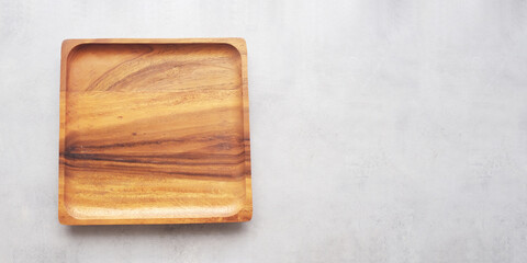 Empty round wooden plate on gray cement table background, banner with copy space, Blank wood tray for food display montage, template, mock up, top view, flat lay