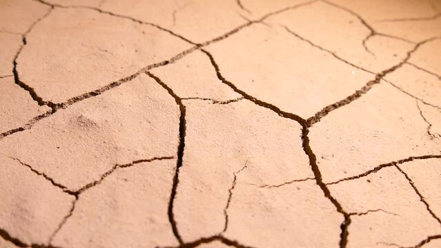 Cracked soil. Global climate change and ecology. Drying out of the desert. Evaporation of water from the soil. Global warming and temperature increase on the Earth. Cracks on the surface.