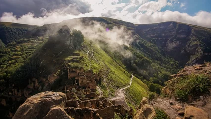 Foto op Canvas The ghost town of Gamsutl in Dagestan. Stone crumbling houses on a mountainside. © sanbeliaev