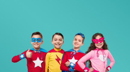 Team of happy superhero children smiling in studio