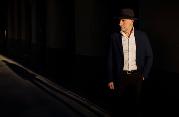 Portrait of adult man in suit with hat on street during sunset. Madrid, Spain