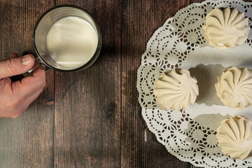 Homemade meringue and milk on a wooden table and art background. Breakfast. Close.up