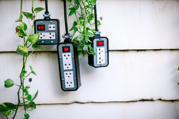 Group of silver colors trailer plug  with on-off switch hanging on the wall.