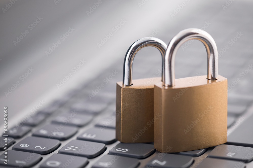 Poster security concept with two metal padlocks on computer keyboard