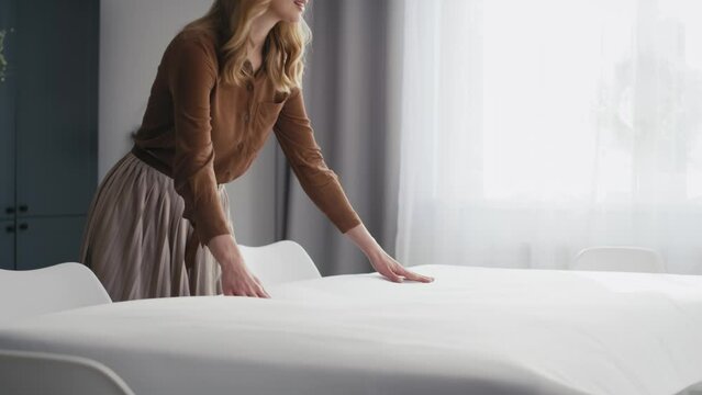 Caucasian woman laying table with a white tablecloth. Shot with RED helium camera in 8K.  