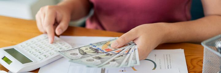 Saving concept the female saver pressing a calculator to estimate the amount of cash