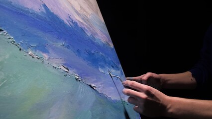 Artist copyist paint seascape with ship in ocean. Craftsman decorator draw as boat sail on blue sea with acrylic oil color. Draw finger, brush, knife palette. Indoor. Dark magic cinematic look.