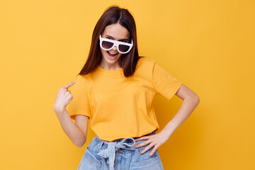 Naklejka premium young woman fashion in yellow t-shirt denim shorts yellow background