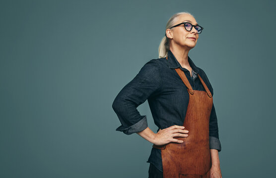 Thoughtful jewellery maker standing in a studio - Powered by Adobe
