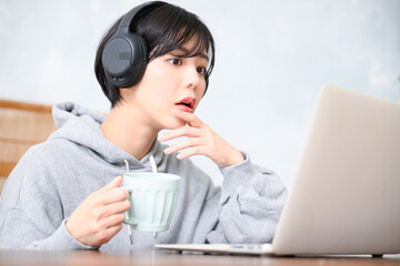 音楽を聴きながらへ～という顔でパソコンで仕事をする女性