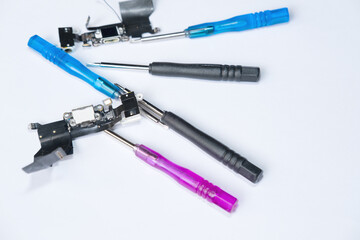Colored instruments, screwdrivers, connectors, tools, cables and circuit boards for phone repair on a white background closeup