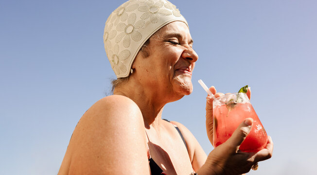 Mature woman enjoying a drink in the summer