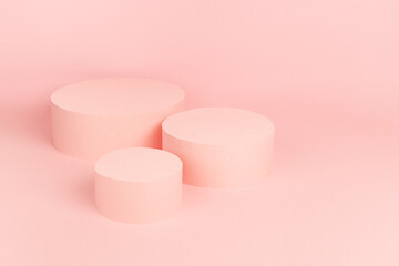 Fashion stage with set of three pastel pink round podiums top view mockup on soft light background, copy space. Trendy template showcase for presentation cosmetic product, goods, advertising, design.