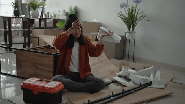 frustrated asian woman while assembling new furniture