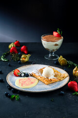 Apple pie with ice-cream decorated with a strawberry, fruit sauce served in a restaurant