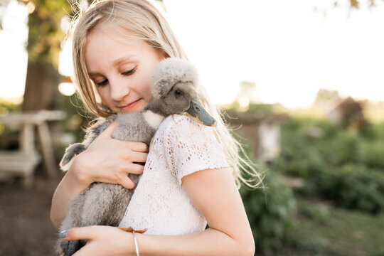 Girl Carrying Duck At Farm