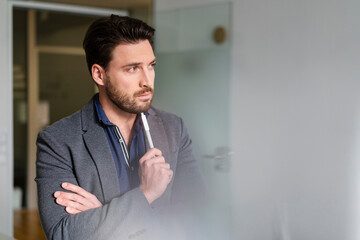 Bearded businessman thinking in office