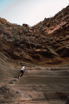 Man climbing steps on rock formation, Barranco de las Vacas, Spain