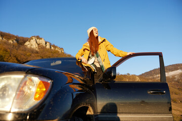 woman traveler near the car admiring the landscape mountains nature Lifestyle