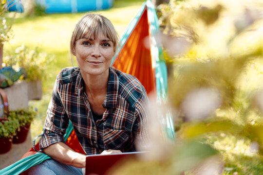 Woman with laptop sitting in hammock